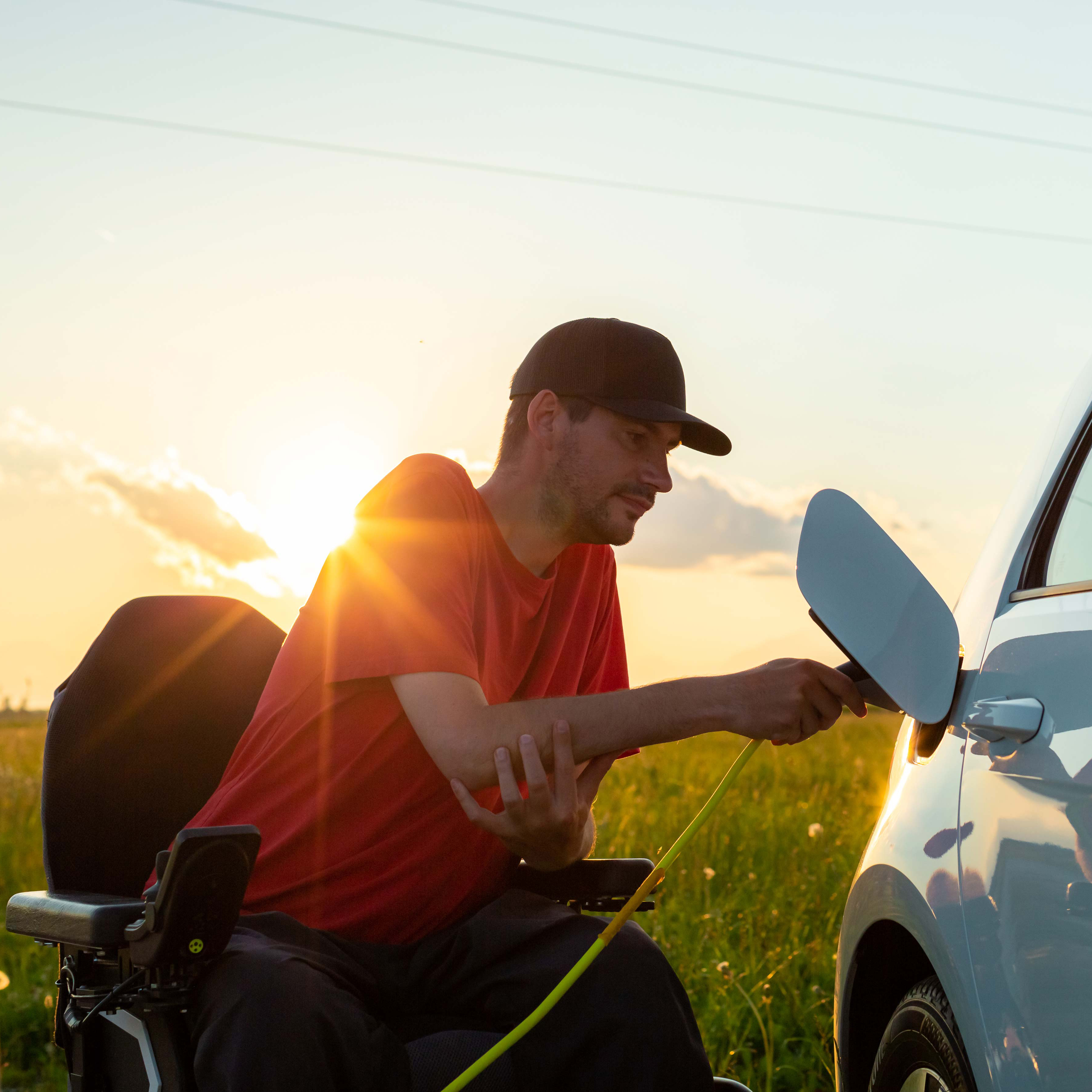 Disabled Man in wheelchair charing electric car